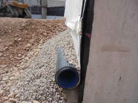 Deckdrain is easily attached to the wall, with the lower end wrapped around the perforated drainage pipe
