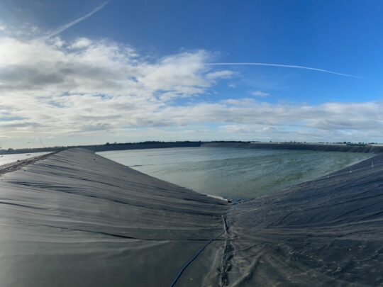 HDPE liner filling with water in the large 22 acre reservoir basin.