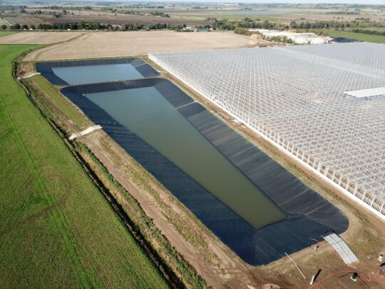 basin collects run-off from the adjacent greenhouse buildings and recycles it for irrigation of the crops.
